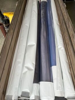 Gereinigte Planen eingerollt in Kisten zur Lagerung.